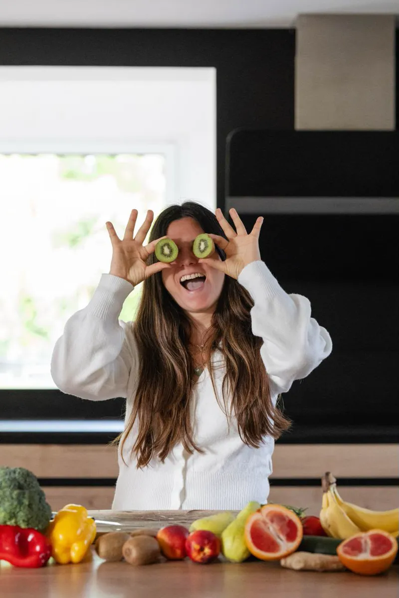 Mélanie Padovani, hilare, se cache les yeux avec deux rondelles de kiwi