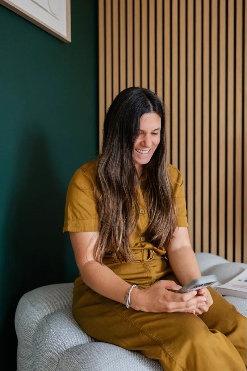 Mélanie Padovani consulte son téléphone en souriant